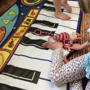 EJ playing with her electronic piano mat