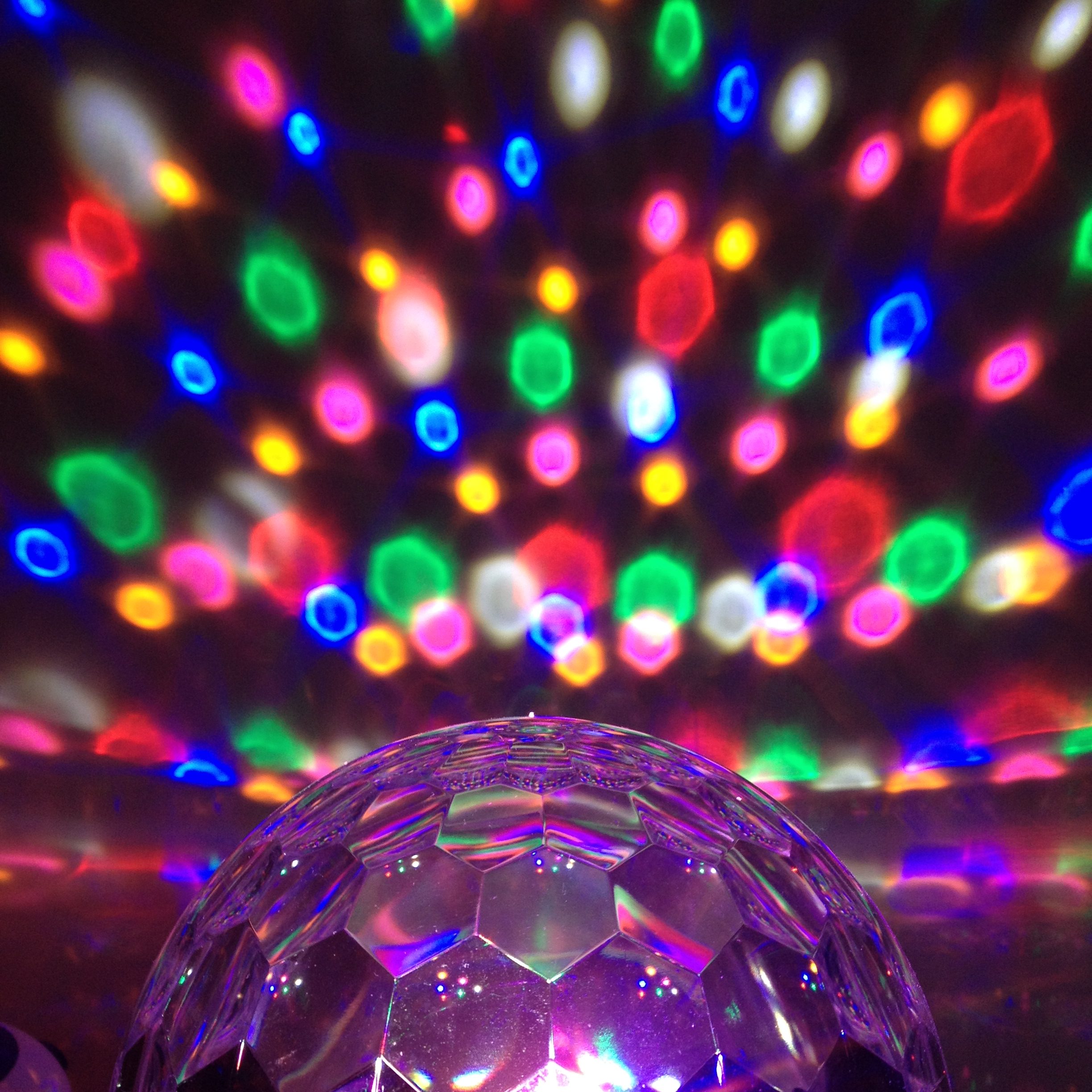 Disco ball light projecting coloured spots onto the wall