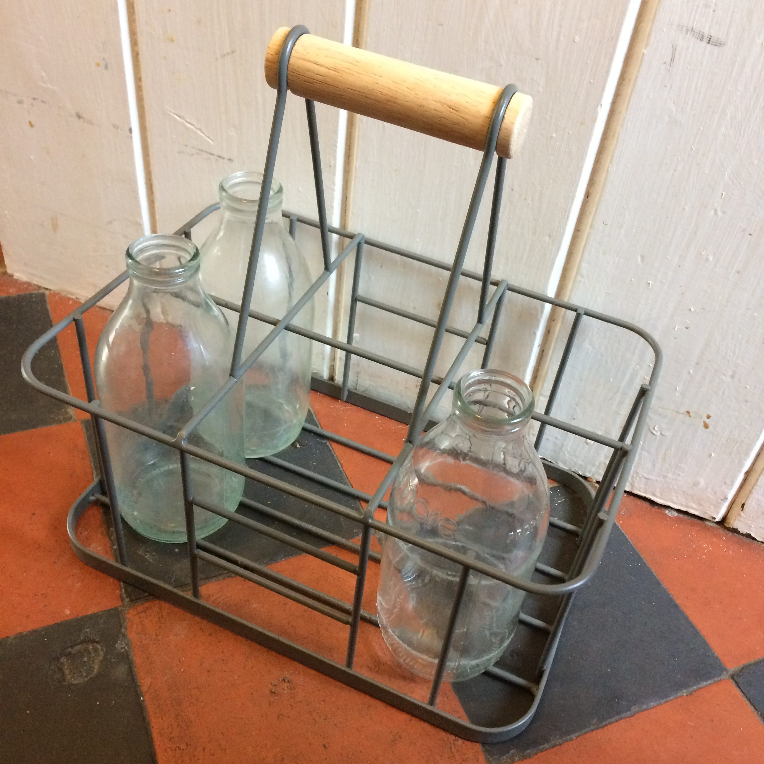Empty glass milk bottles in a wire rack